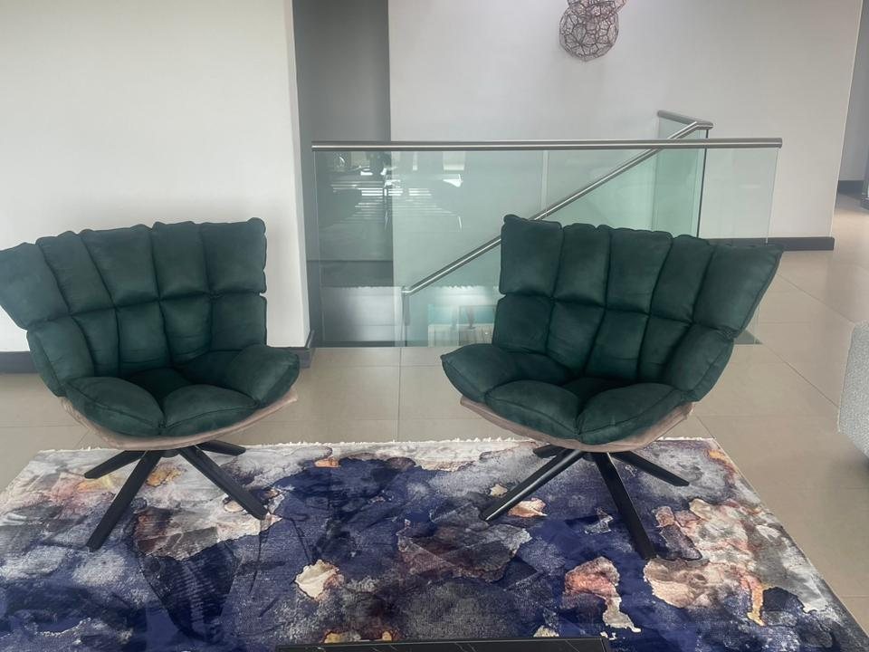 Two green velvet swivel chairs on a patterned rug in a Johannesburg home after cleaning